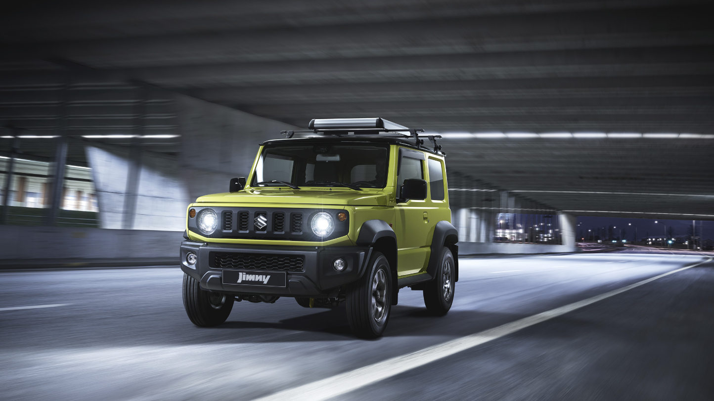 A yellow-green Suzuki Jimny driving through a tunnel.